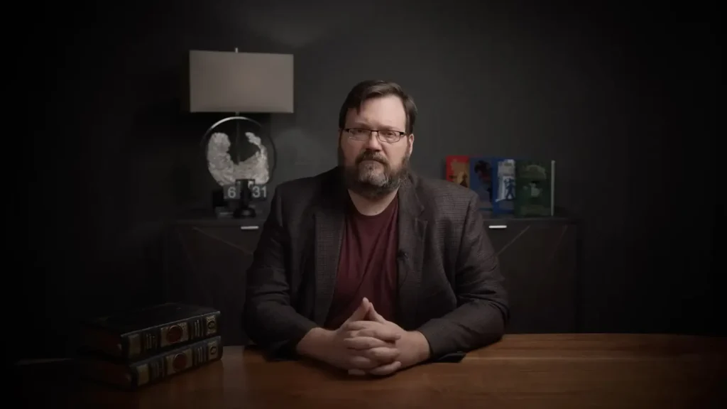 Brandon Sanderson at desk looking serious 1